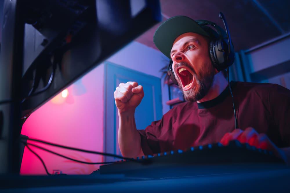 Homem demonstrando emoções durante jogo de computador