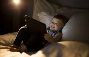 Imagem mostrando uma criança sorrindo enquanto usa um tablet