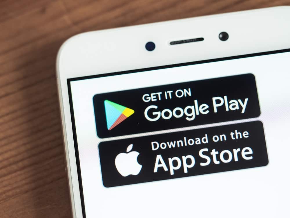 Na imagem, a tela de um smartphone mostra os slogans de ambas as lojas de aplicativos das empresas Apple e Google; na ordem em que aparedem, tem-se: Google Play em cima, App Store abaixo.