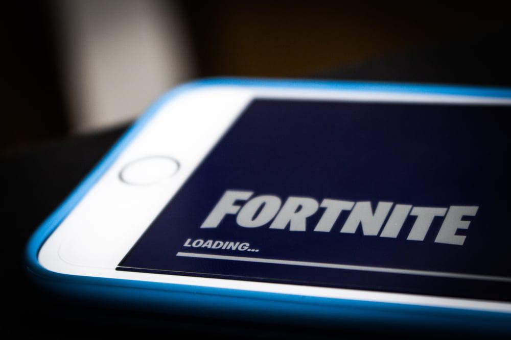 Smartphone exibe uma tela de carregamento do jogo Fortnite, da Epic Games