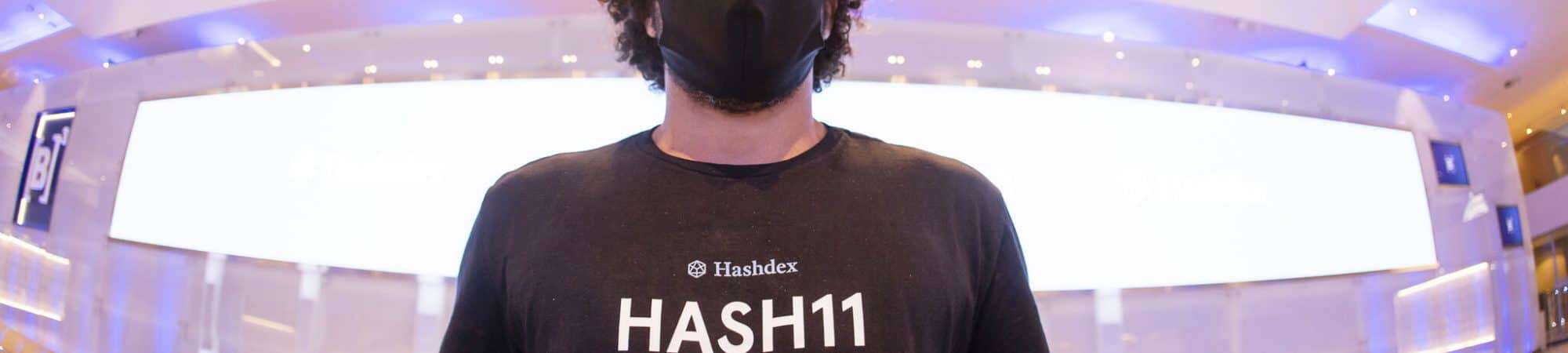 Imagem mostra um jovem com uma camiseta onde pode-se ler a palavra HASH11, sigla do ticker de negociação do primeiro fundo ETF de criptomoedas brasileiro