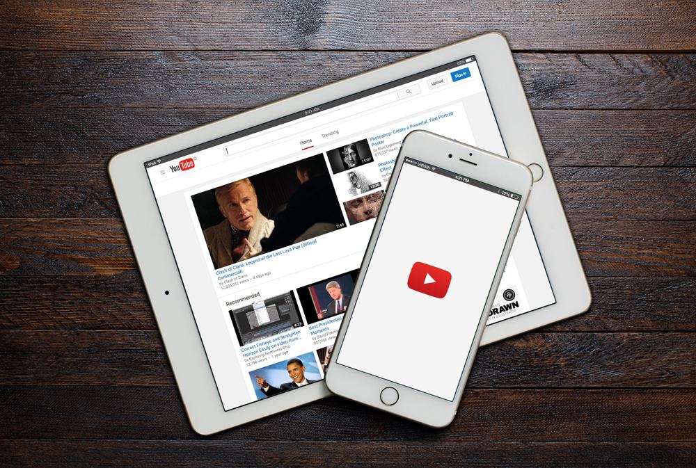 Celular e tablet com o aplicativo do YouTube aberto