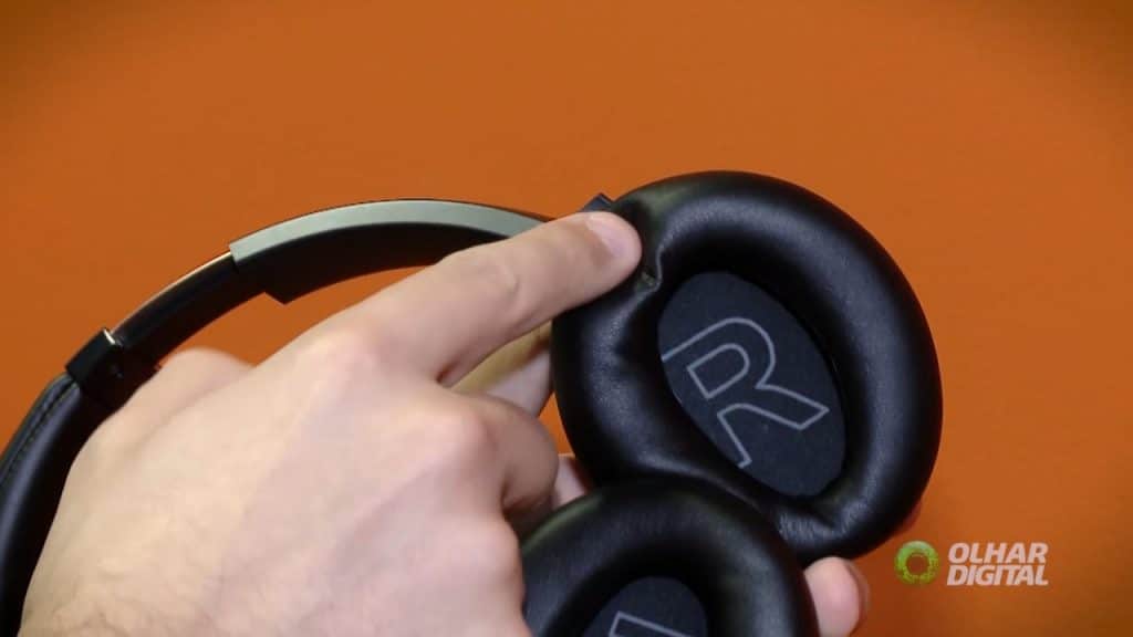 Imagem mostra a parte interna do headset Soundcore Life Q20, da Anker, com uma mão apertando suas almofadas como teste de conforto.