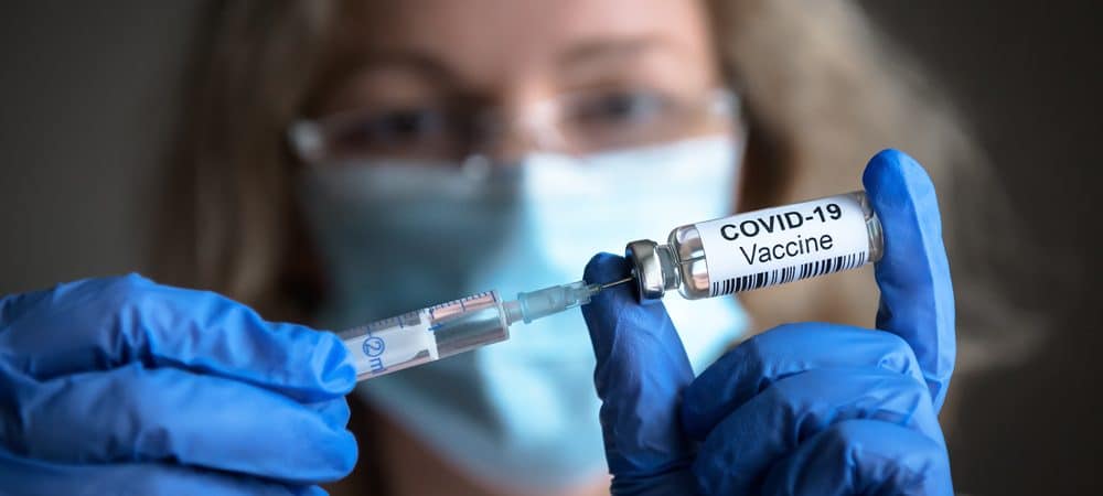 Mulher enchendo uma seringa com dose da vacina contra a Covid-19