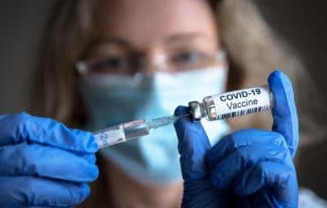 Mulher enchendo uma seringa com dose da vacina contra a Covid-19