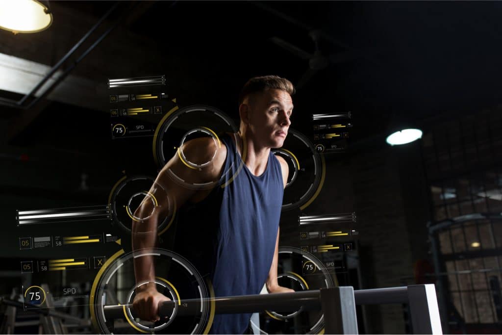 Imagem mostra um atleta praticando exercícios de musculação, com uma regata cheia de símbolos tecnológicos, fazendo alusão à "fibra programável" da matéria