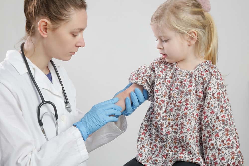 médica avaliando criança com alergia