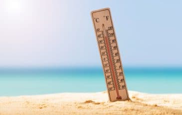 termometro fincado na areia da praia mostrando calor