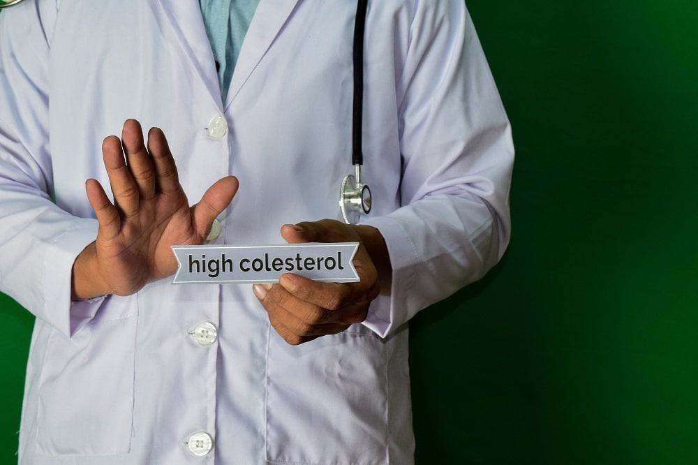 médico segura placa escrita colesterol alto