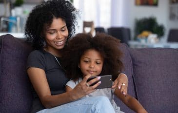 Mãe e criança assistem vídeo no celular