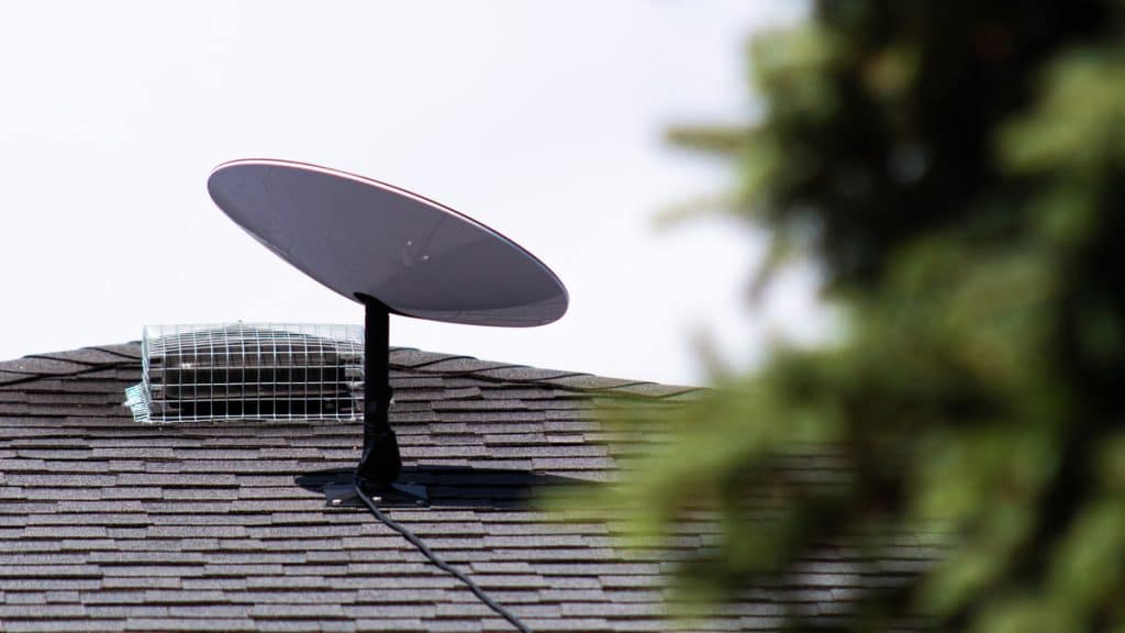 Antena da Starlink posicionada no telhado de uma casa.