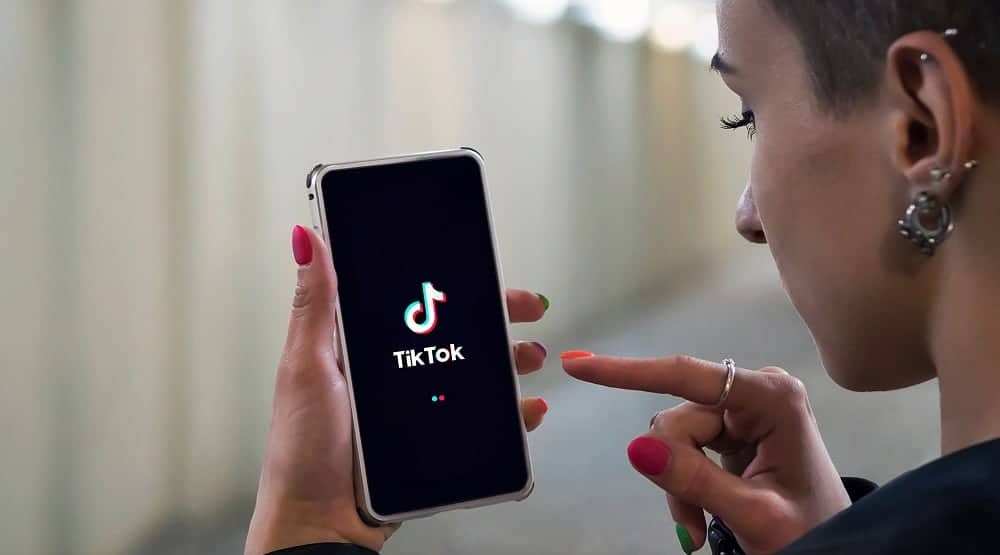 Woman holding cellphone and showing TikTok app