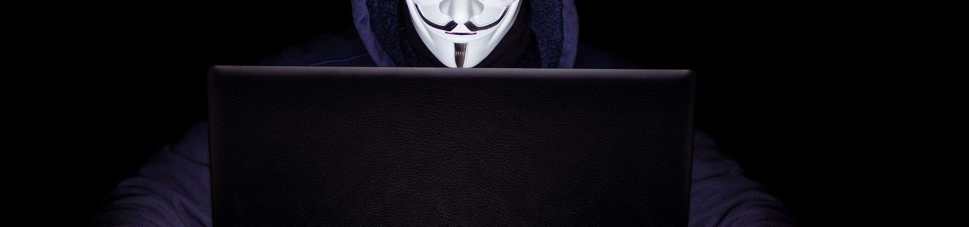 hacker do anonymous com máscara do guy fawkes na frente do notebook
