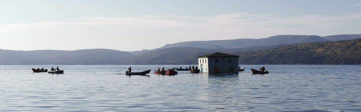 casa sendo transportada pelas águas de um lago