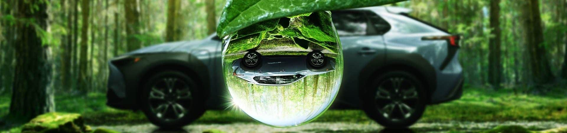 Imagem do SUV elétrico Solterra, da Subaru, refletida em uma gota de orvalho
