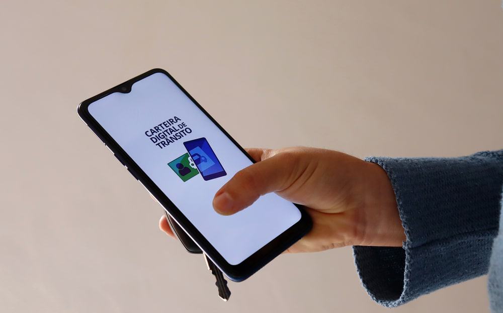 Motorista exibe o aplicativo da Carteira Digital de Trânsito aberto na tela de um celular