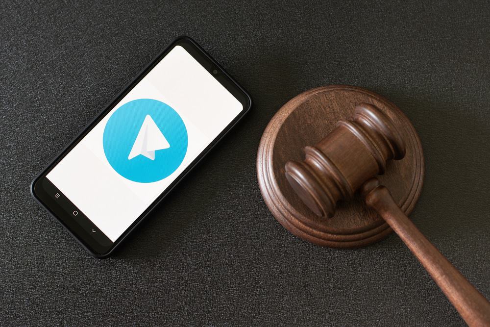 Aplicativo Telegram na tela do smartphone e martelo de um juiz