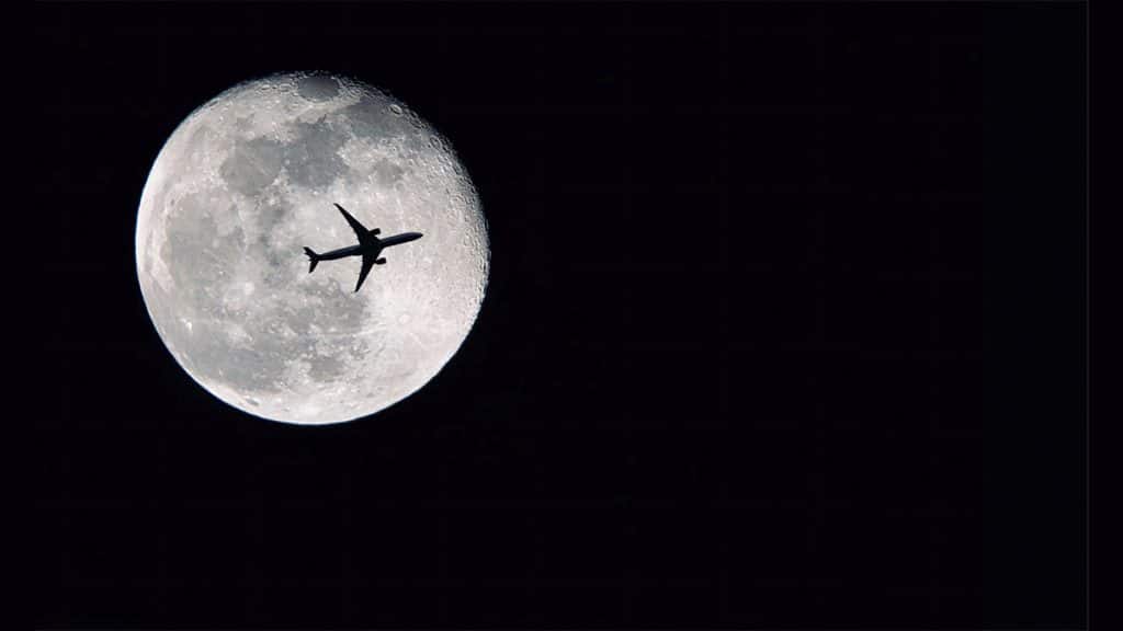 Avião passando na frente da Lua