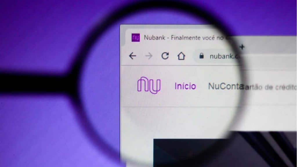 Lupa sobre tela de computador com site do Nubank aberto em navegador