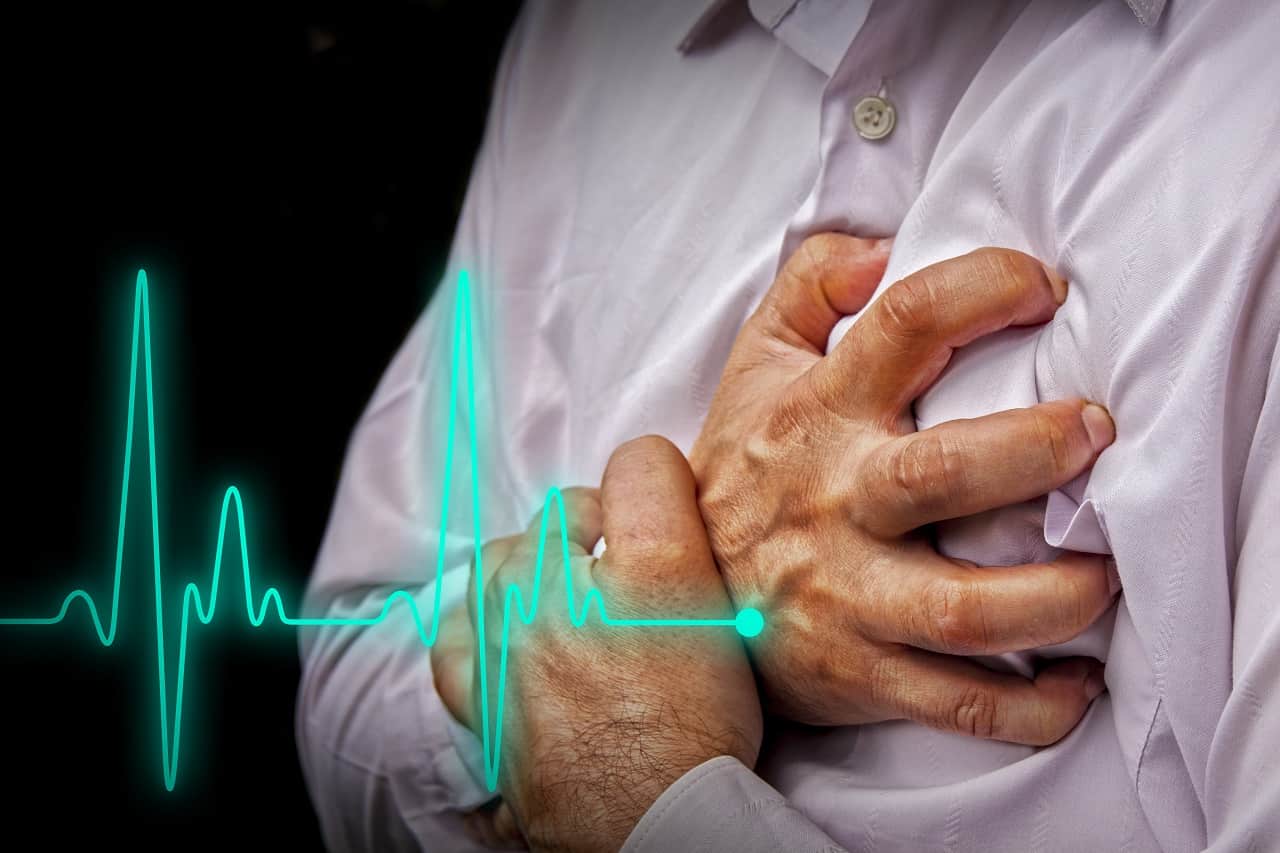 Imagem de homem com a mão sobre o peito sobreposta por desenho de linha de batimentos cardíacos